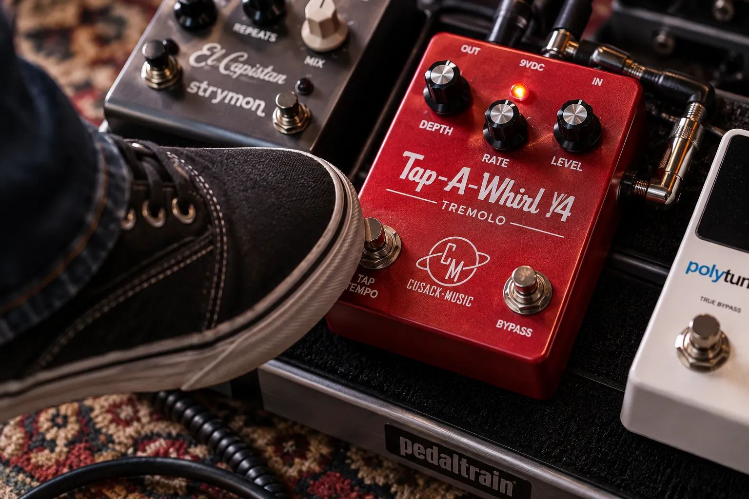 Guitarist tapping the tempo footswitch on a red Tap-A-Whirl V4 tremolo pedal